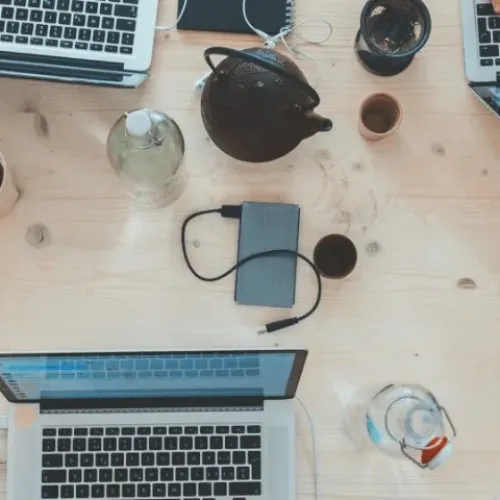 A bunch of laptops on a table from above